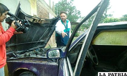 La víctima muestra el vehículo quemado a la prensa