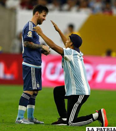 Un hincha argentino de rodillas frente a Lionel Messi /as.com