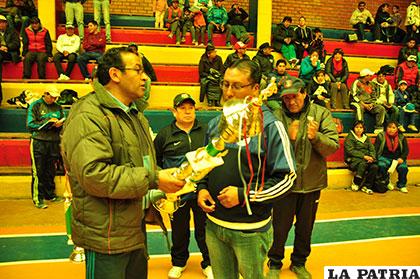 Marco Guerrero entrega el trofeo al representante de Yaku SeLA