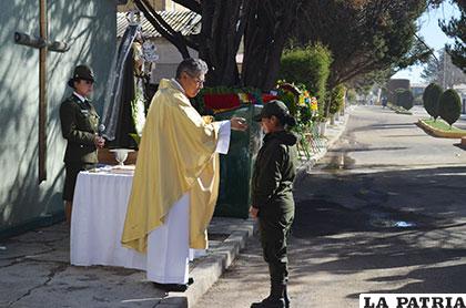 Una policía recibe la comunión durante la misa