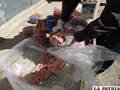 Personal del Sedes destruye los envoltorios de las salchichas antes de entregárselas a GUAO