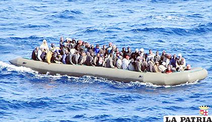 Una barcaza con inmigrantes africanos a bordo, cerca de la isla italiana de Lampedusa /Recortes de Oriente Medio