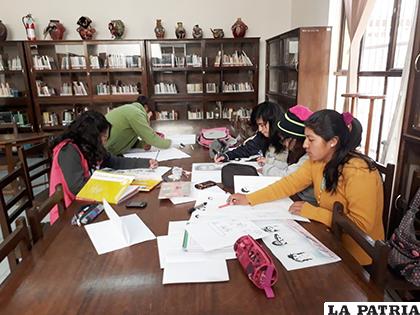 Estudiantes trabajando en sus deberes escolares dentro la Biblioteca