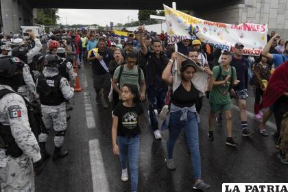 Migrantes pasan junto a la Guardia Nacional mexicana /AP Foto/Isabel Mateos