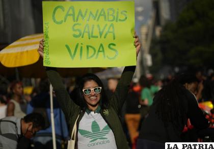 Una manifestante sostiene un letrero durante una protesta para exigir la legalización de la marihuana /AP Foto/Andre Penner