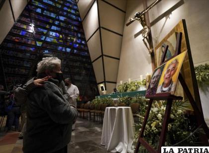 Una feligrés se lamenta frente a las imágenes de los sacerdotes jesuitas Javier Campos Morales y Joaquín César Mora Salazar /AP Foto/Fernando Llano