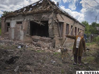 La residente local Tetyana apunta a su casa dañada por el cañoneo ruso en Bajmut /AP Foto /Efrem Lukatsky
