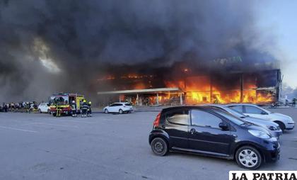 Bomberos tratan de extinguir las llamas en el centro comercial /Servicio Estatal de Emergencias de Ucrania vía AP

