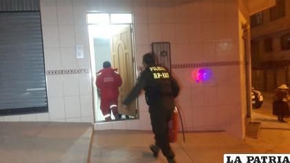 Funcionarios policiales ingresan para apagar el fuego en una casa céntrica de Oruro /LA PATRIA