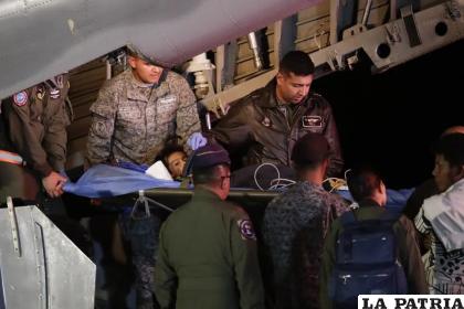 Personal militar saca de un avión a uno de los cuatro niños indígenas que estaban desaparecidos /AP/Iván Valencia