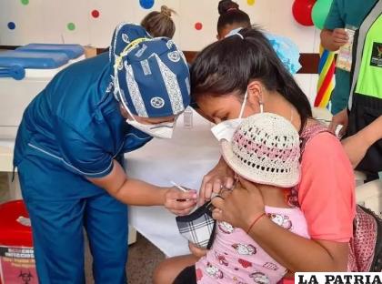Personal de salud vacuna a una infante /ATB