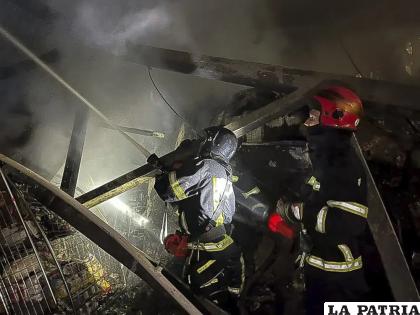 Trabajadores de los servicios de emergencias extinguen un incendio tras el impacto de un cohete ruso /Oficina de Prensa de los Servicios de Emergencias de Ucrania vía AP