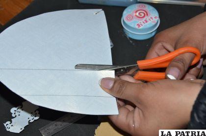 PASO 4
Cortar un trozo de 11 cm x 5 cm de la cartulina blanca texturada y proceder a perforar con la perforadora esquinera.
