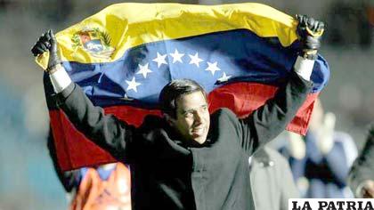 César Farías D.T. de la selección de Venezuela con la bandera de su país