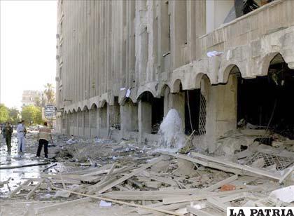 Imagen muestra a varios curiosos mientras inspeccionan el lugar tras explotar un coche bomba ante la sede de la Dirección de Finanzas siria en la provincia de Aleppo (Siria) /EFE/Sana