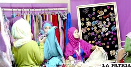 Varias mujeres observan las prendas de un expositor de velos y complementos en el Festival Nacional del Hiyab /EFE