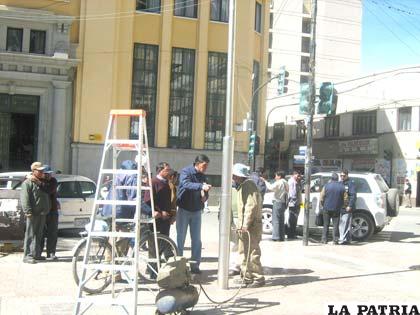 Momento en que ciudadanos reclaman el pintado del poste que sostiene el reloj en la plaza