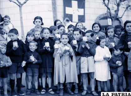 Niños en Barcelona en 1939 con un vaso de leche condensada distribuida por la Cruz Roja suiza durante la Guerra Civil Española