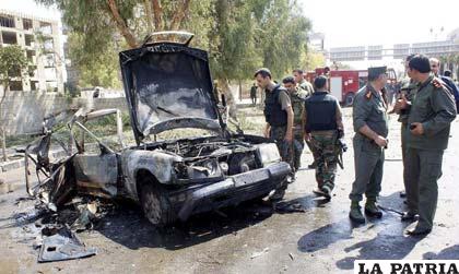 Policía de Siria inspecciona la escena donde un coche bomba explotó en Mazzeh 