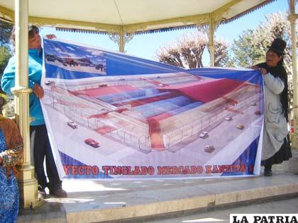 Dos comerciantes muestran el proyecto del tinglado del mercado Kantuta