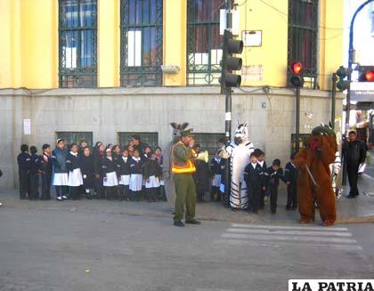 Paquito junto al cabo Aruquipa enseñan a los niños a cruzar la calle