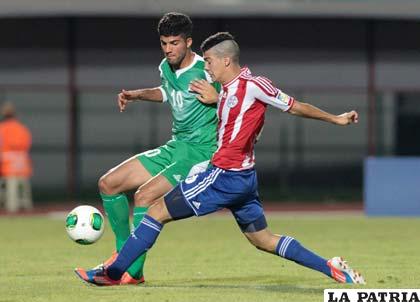 El iraquí Jabbar Shwkan (i) disputa el balón con el paraguayo Iván Ramírez (d)