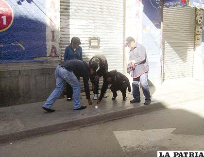 UNO DE LOS SUJETOS (ANTISOCIAL CÓMPLICE), DERRAMA MONEDAS AL SUELO DELANTE DE LA VÍCTIMA, LA MISMA GENEROSAMENTE LEVANTA LAS MONEDAS.