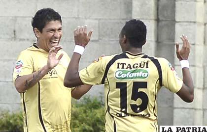 Cabrera (der) celebra la anotación junto al otro goleador Aguirre