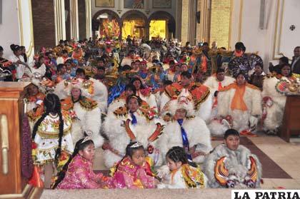 Los danzarines de la Auténtica al pie de la Virgen del Socavón, motivo principal del Carnaval de Oruro