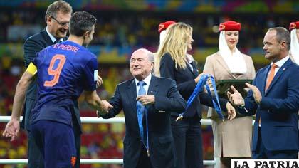 El presidente de la FIFA, Joseph Blatter le estrecha la mano a Van Persie