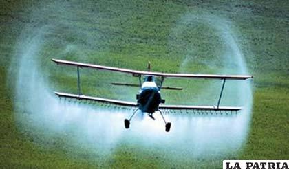 Una avioneta vuela fumiga con pesticidas vastas áreas de sembradíos de soya