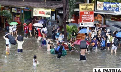 Filipinos caminan por las calles inundadas /telemundo33.com