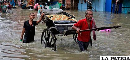 Ciudadanos del estado de Assam, en el Noreste de la India con el agua por encima de las rodillas