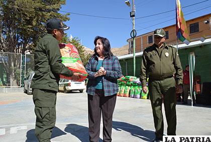 El comandante del CAC, subteniente Maita recibe de Gloria Romano la dotación de alimento balanceado