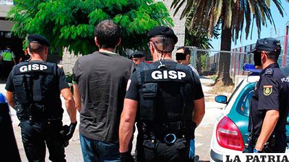 Uno de los policías lusos es llevado aprehendido /La Vanguardia