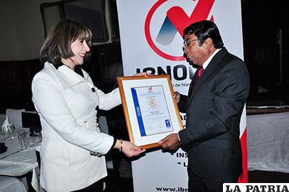 ?scar Dorado recibe la certificación de manos de la directora regional de Ibnorca, Martha Leclere