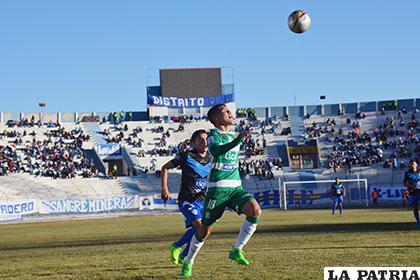 Luis Haquín intenta dominar el balón ante la presión de Ariel Juárez