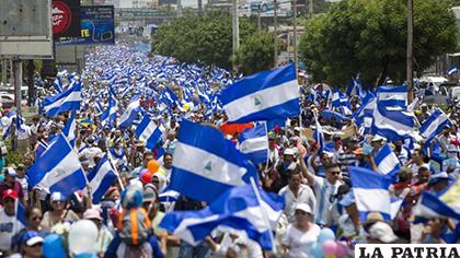 Miles de personas con banderas de Nicaragua participan durante la 