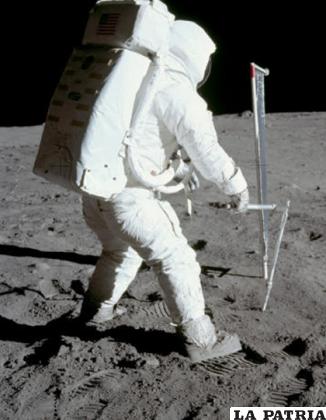 El astronauta Edwin Aldrin en el proceso de tomar una muestra de suelo lunar. En el fondo está el experimento del viento solar /NASA
