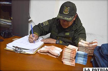 El suboficial Guzmán realiza el registro de cada uno de los billetes secuestrados /LA PATRIA