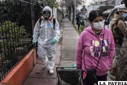 Un trabajador municipal limpia y desinfecta las calles del barrio San Miguel de Santiago /infobae.com
