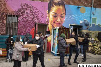Voluntarios movilizan despensas de alimentos que serán donadas mientras personas reciben información sobre las vacunas contra el COVID-19 en el centro comunitario Mixteca /AP Foto/Eduardo Munoz Alvarez, Archivo