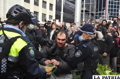 Un manifestante es arrestado por la policía en una protesta ante el Ayuntamiento de Sydney contra los encierros por el coronavirus /Mick Tsikas/AAP Image vía AP