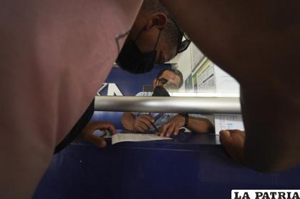 Migrantes compran boletos de autobús luego de recibir documentos que les permiten viajar legalmente por México 
/Foto AP/Marco Ugarte