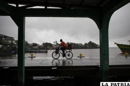 Un hombre monta bicicleta bajo la lluvia que acompaña a la tormenta tropical Bonnie en Bluefields, Nicaragua /AP Foto/Inti Ocon
