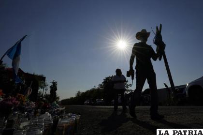 Roberto Marquez coloca una cruz de madera en un monumento conmemorativo a 53 migrantes muertos 
/AP Foto /Eric Gay