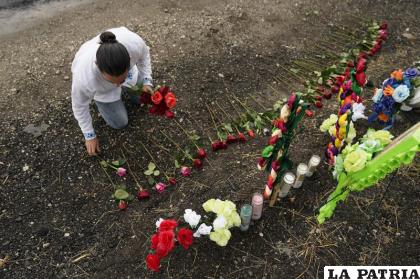 Carlow Eduardo Espina coloca unas rosas en un altar improvisado instalado en el lugar donde encontraron a decenas de personas muertas /AP Foto/Eric Gay/Archivo