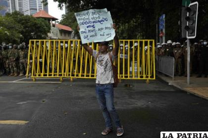 Un manifestante muestra un cartel con mensajes antigubernamentales durante una protesta /AP Foto /Eranga Jayawardena