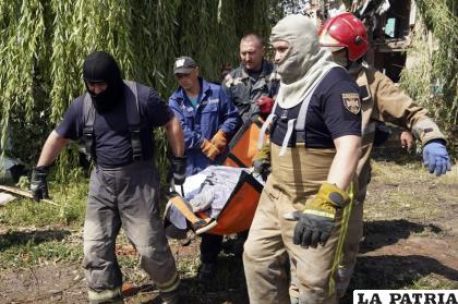 Rescatistas trasladan el cuerpo de una mujer asesinada en un ataque ruso /AP Foto /Andrii Marienko