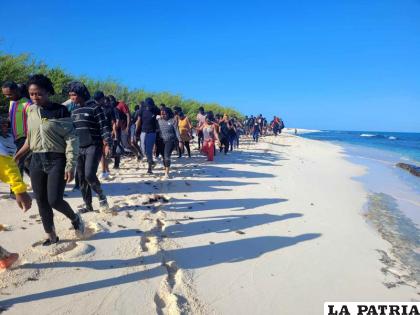 Migrantes rescatados caminan a la orilla de la playa / Puerto Rico’s Department of Natural Resources via AP